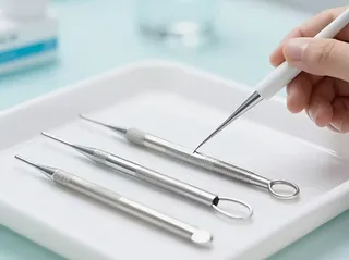 A gloved hand holding a sampling instrument above a clinical tray.